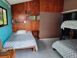 - 2 lits dans une chambre dotée de murs en bois dans l'établissement Residencia Panorámica Lomas de Cocoyoc, à Texcalpan
