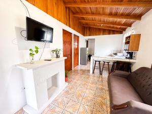 uma sala de estar com um sofá e uma televisão na parede em Edén Guest House em Monteverde