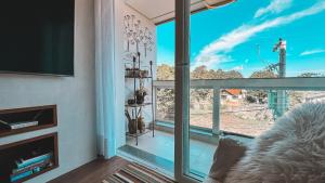 a living room with a large glass window at Ao Lado da Roda Gigante in Canela