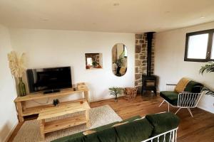 a living room with a couch and a flat screen tv at Field house in Pleumeur-Bodou