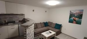 a small living room with a couch and a kitchen at Stan na dan-MARKOVIĆ- in Dušanovac (historical)