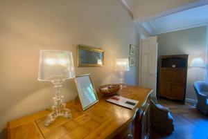 - un bureau en bois avec deux lampes au-dessus dans l'établissement L'historien - avec balcon coeur de Nîmes, à Nîmes