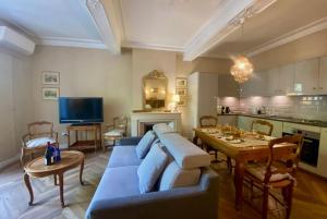 un salon avec un canapé bleu et une table dans l'établissement L'historien - avec balcon coeur de Nîmes, à Nîmes 13 autres photos