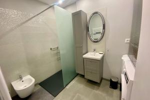 une salle de bain avec un lavabo, des toilettes et un miroir dans l'établissement L'historien - avec balcon coeur de Nîmes, à Nîmes