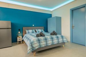 1 dormitorio con 1 cama con pared azul en Frida's Home for 2 in Kozani, en Kozani