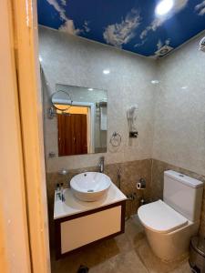 a bathroom with a toilet and a sink and a mirror at Malakan Boutique Nizami Hotel in Baku