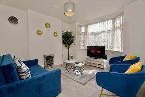a living room with two blue couches and a tv at Serene 3Bed Escape - Fully Furnished Holiday Haven in Coventry