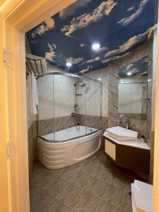 a bathroom with a tub and a toilet and a sink at Malakan Boutique Nizami Hotel in Baku