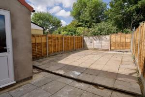 a backyard with a fence and a driveway at Serene 3Bed Escape - Fully Furnished Holiday Haven in Coventry