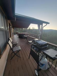 a screened in porch with a grill on a deck at Sunset Ridge: THE million dollar view in Ruidoso