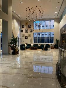 duży salon z żyrandolem w budynku w obiekcie Eliana Hotel w mieście Al-Chubar