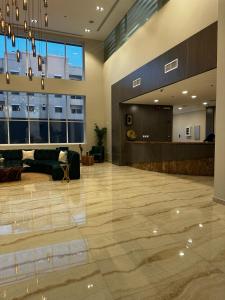 a lobby with a couch and a table in a building at Eliana Hotel in Al Khobar