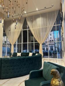 a living room with a couch and a large window at Eliana Hotel in Al Khobar