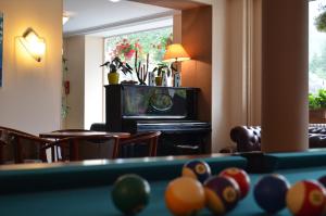 a living room with a pool table and a television at Hotel Le Beau Site in Saint-Pierre-de-Chartreuse