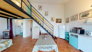a kitchen with a table and a staircase in a room at Le CaRaMeLle di Baratti in Baratti