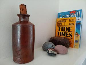 a rusty bottle sitting next to a book and some rocks at The Captain's House Charlestown St Austell in Charlestown