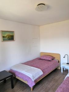 a bedroom with a bed with a purple blanket at ROSEMARIN in Koper