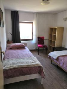 a bedroom with two beds and a window and a chair at ROSEMARIN in Koper