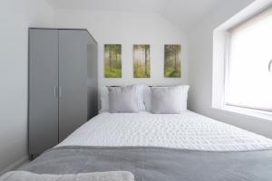 a white bedroom with a bed and a window at 3 Bed House in Rochester 4 beds sleeps 7 in Wainscot