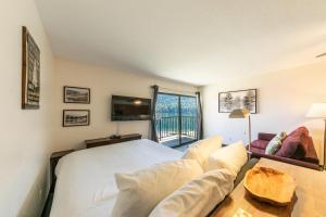 a bedroom with a bed and a couch and a window at Striking Studio w/Lake View #244 at Donner Lake Village in Truckee