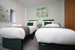 two beds sitting next to each other in a room at Bright 1Bedroom Apartment, Central Location with Balcony in Bristol