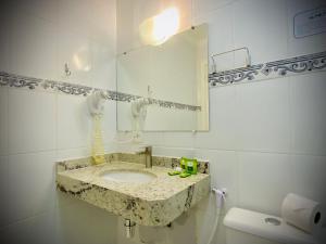 y baño con lavabo y espejo. en Pousada Parque das Flores, en Campos do Jordão