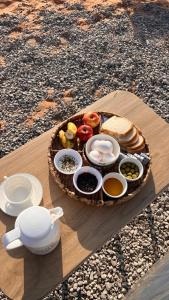 a tray of food on a wooden table with a plate of food at Marbella bungalows desert in Bidiyah