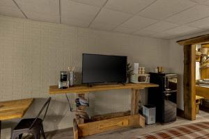 a living room with a television on a wooden shelf at Stonegate Lodge King Bed WIFI 50in Roku TV Salt Water Pool Room #102 in Eureka Springs