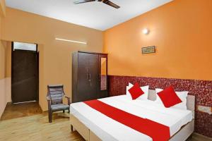 a hotel room with a bed and a chair at Prince Residency in Greater Noida