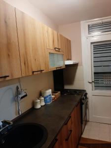 a kitchen with wooden cabinets and a counter top at Dvosoban stan u širem centru in Pirot