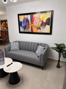 una sala de estar con sofá y una pintura en la pared en Flor de lirio, en Juan López