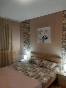 a bedroom with a large bed with flowers on the wall at Dvosoban stan u širem centru in Pirot