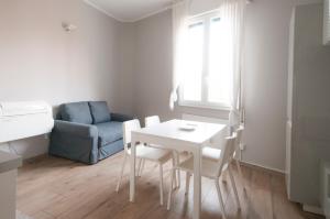 un piccolo soggiorno con tavolo e sedie bianchi di Blanco Apartment - AmbrogioHost a Bologna