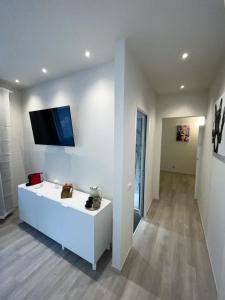 een woonkamer met een tv aan een witte muur bij 7Suites in Empoli