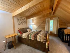 - une chambre avec un grand lit dans une cabane en rondins dans l'établissement Talkeetna Log Cabin with Hot Tub Unit 1, à Talkeetna