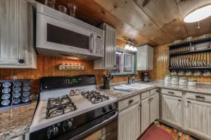 a kitchen with a stove and a microwave at Two Bedroom Cabin Used To Belong to Deborah Winger! in Ruidoso