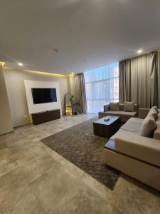 salon z kanapami i telewizorem z płaskim ekranem w obiekcie Eliana Hotel w mieście Al-Chubar