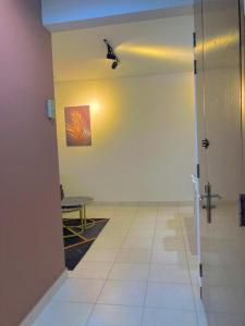 a hallway with a table and a room with a door at NR CYBER ROOMSTAY 2-Shared Apartment in Cyberjaya