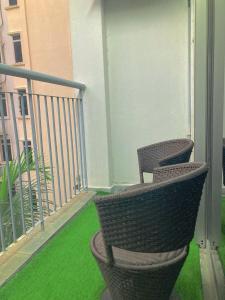 two chairs sitting on a balcony with green grass at NR CYBER ROOMSTAY 2-Shared Apartment in Cyberjaya