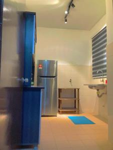 a kitchen with a stainless steel refrigerator and a sink at NR CYBER ROOMSTAY 2-Shared Apartment in Cyberjaya