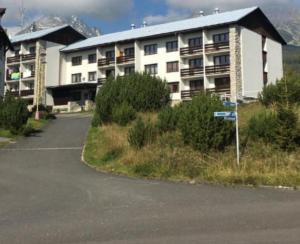 a large apartment building with a parking lot in front of it at UBYTOVANIE POD GERLACHOM in Vysoké Tatry