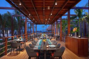 a restaurant with tables and chairs on a deck at Dreams Flora Resort & Spa in Punta Cana