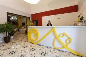 a woman standing behind a counter with a x sign at Hotel del Sole in Pompei