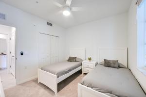two beds in a bedroom with white walls at Breezy Ave Maria Condo with Golf Course On-Site! in Harker