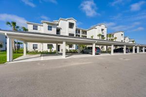 a large white house with a parking lot at Breezy Ave Maria Condo with Golf Course On-Site! in Harker