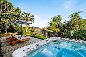 bañera de hidromasaje en una terraza con sombrilla en HAMPTON HOUSE PACIFIC PALISADES CA Ocean View Family & Pet Friendly Weekly & Monthly Discounts, en Los Ángeles