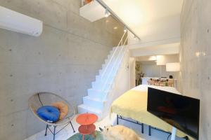 Habitación con cama, TV y escaleras. en Toyocho SA-KU-RA - Vacation STAY 44020v, en Tokio