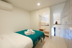 a bedroom with a bed with a green blanket at Toyocho SA-KU-RA - Vacation STAY 44020v in Tokyo