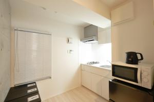 a small kitchen with a microwave and a sink at Toyocho SA-KU-RA - Vacation STAY 45258v in Tokyo