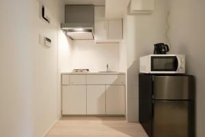 una piccola cucina con frigorifero e forno a microonde di Toyocho SA-KU-RA - Vacation STAY 45258v a Tokyo